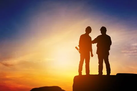 Silhouette of Engineer and worker standing on stone thinking of project Fotos de archivo