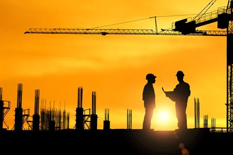 Silhouette of engineer explaining the construction worker to the building pla Stock Photos