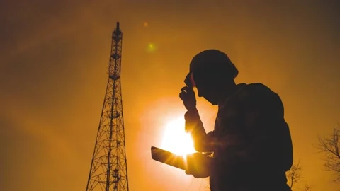 Silhouette engineer man a studying telecommunication tower pillars. concept Stock Footage 132984553