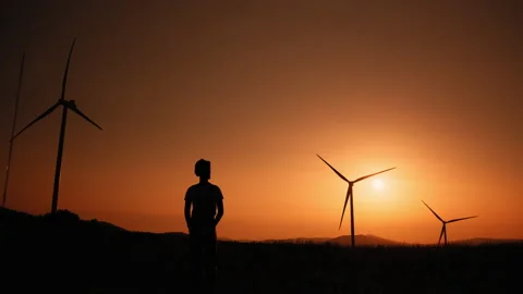 Silhouette Engineer standing on field with windmills. Dreaming of a clean and Stock Footage 170658211