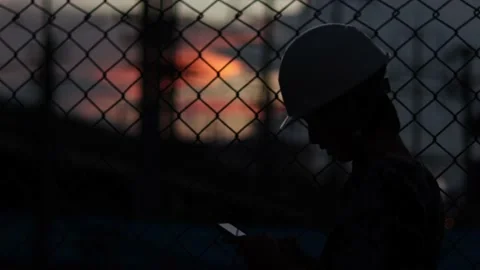 Silhouette engineer standing orders for construction crews and using phone. Stock Footage 165433961