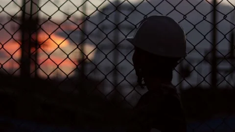 Silhouette engineer standing orders for construction crews and using phone. Stock Footage 165433963