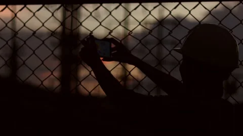 Silhouette engineer standing orders for construction crews and using phone. Stock Footage 165434023