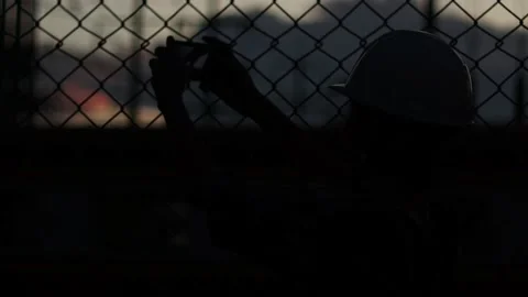 Silhouette engineer standing orders for construction crews and using phone. Stock Footage 165434114