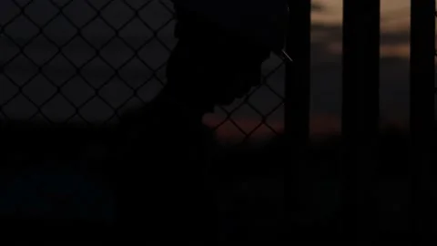 Silhouette engineer standing orders for construction crews and using phone. Stock Footage 165434140