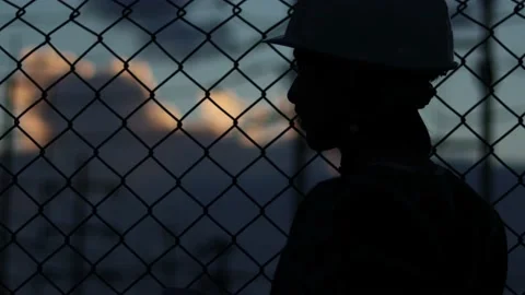 Silhouette engineer standing orders for construction crews and using phone. Stock Footage 165434166