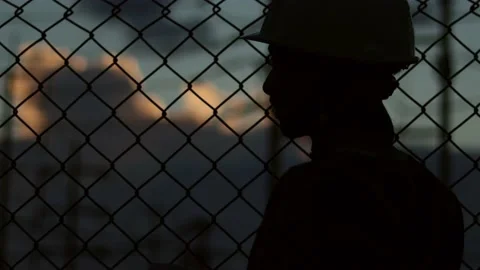 Silhouette engineer standing orders for construction crews and using phone. Stock Footage 165434174
