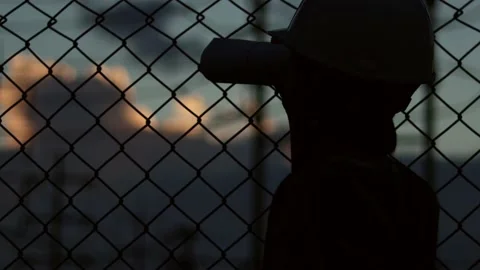 Silhouette engineer standing orders for construction crews and using phone. Stock Footage 165434240