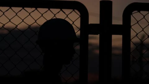 Silhouette engineer standing orders for construction crews and using phone. Stock Footage 165434492