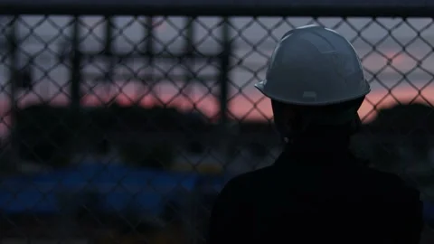 Silhouette engineer standing orders for construction crews and using phone. Stock Footage 165437385