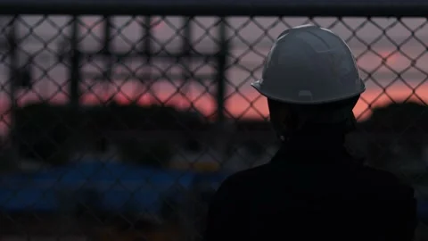 Silhouette engineer standing orders for construction crews and using phone. Stock Footage 165437470