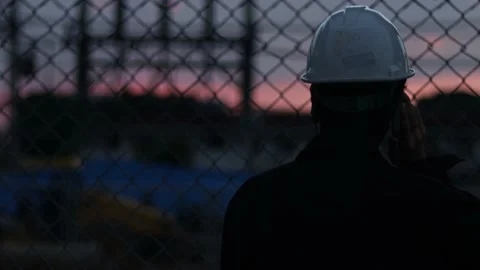 Silhouette engineer standing orders for construction crews and using phone. Stock Footage 165437573