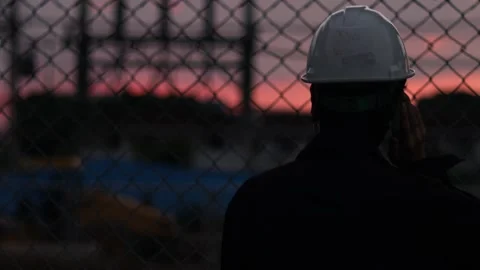 Silhouette engineer standing orders for construction crews and using phone. Stock Footage 165437648