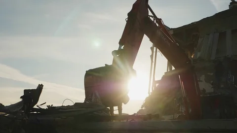 Silhouette of excavator disassembling debris of old arena 스톡 동영상 127742330