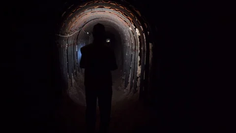Silhouette Exploring Dark Arched Underground Tunnel with Flashlight Vídeos de archivo 334939446