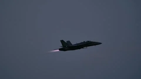 Silhouette of F-18 in Flight Engaging Afterburner with Exhaust Flame Stock Footage 294156154
