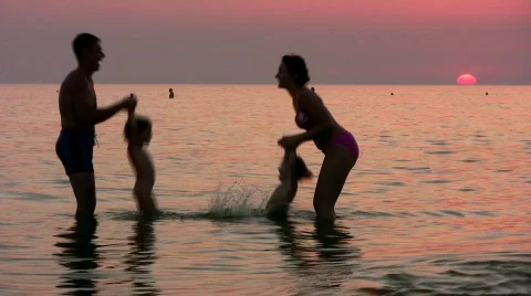 Silhouette family of four on sunset sea Stock Footage