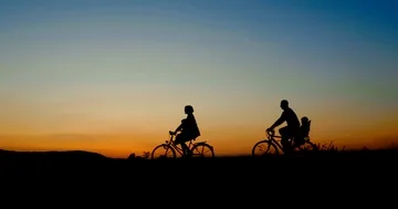 Silhouette of Family Riding Bikes in Beautiful Summer Evening Stock Footage