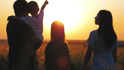 Silhouette family. Teamwork. Parents and children in a wheat field at sunset Stock Footage