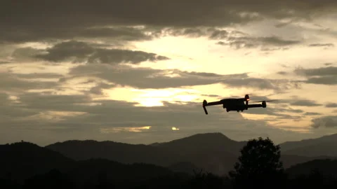 Silhouette Farmer using drone flying navigating above farmland with beautiful. Stock Footage 158912211