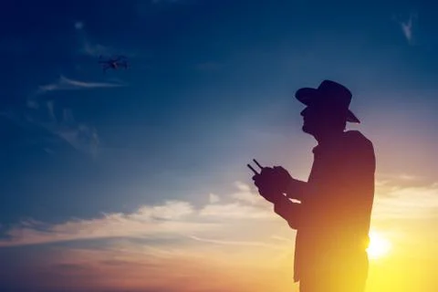 Silhouette of farmer using drone remote control Foto stock