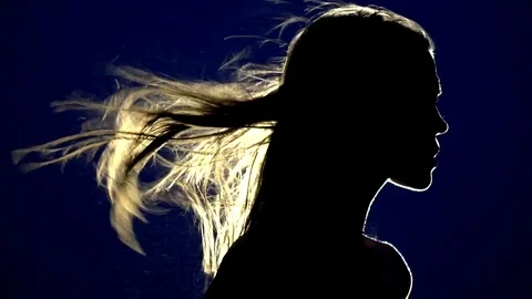 Silhouette of a female mummy with flying hair in the rays of light calls for a Stock Footage