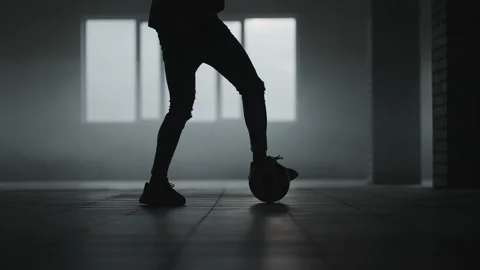 The silhouette of a football player training in an underground parking lot in Stock Footage