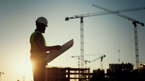 Silhouette of foreman or architect standing against building machinery and sky Stock Footage 317806331
