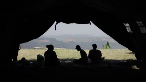 Silhouette of four people talking inside a big tent Stock Footage 204852023