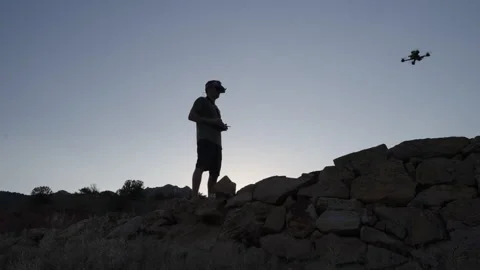 Silhouette of FPV Drone Pilot Taking Off in Mountain Landscape Stock Footage 315975173
