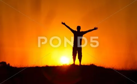 Silhouette of freedom man on the sunset Stock Photos