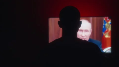Silhouette in front of TV screen, watching russian president Putin speech Stock Footage 215936666