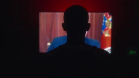 Silhouette in front of TV screen, watching president Putin declares martial law Stock Footage 219565364