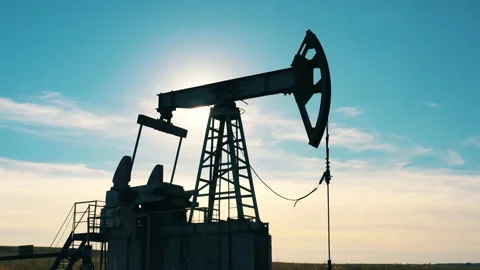 Silhouette of a functioning oil pumpjack in an oil field Video stock 144098892