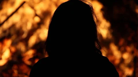Silhouette of girl in front of massive fire Stock Footage 122306918