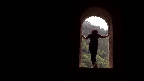 The silhouette of a girl standing in the arch of an ancient Christian temple Stock Footage