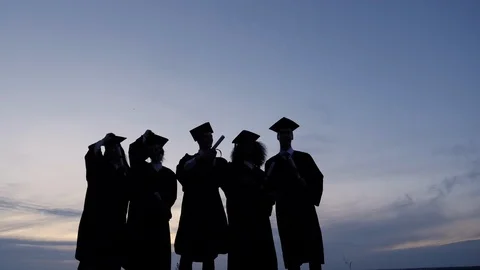 Silhouette of Graduating Students Throwing Caps In The Air. Stock Footage