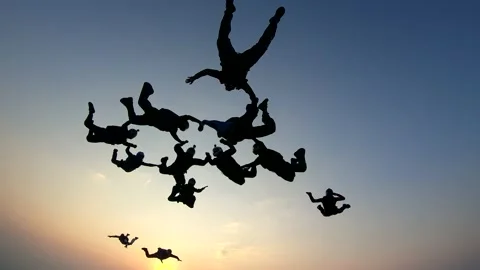Silhouette of a group of skydivers jumping at the end of the day. Stock Footage 130757852