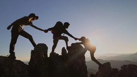 Silhouette of Group team tourists lends helping hand climb cliffs mountains.. Stock Footage 336934553