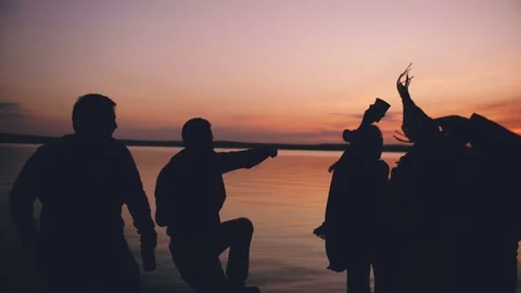 Silhouette of Group young dancing people have a party at beach on sunset Stock Footage