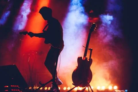 Silhouette Of Guitar Player In Action On Stage Stock Photos