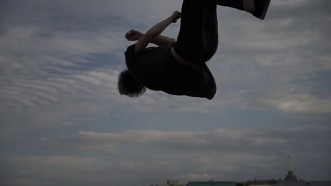 Silhouette of a guy doing a somersault Видео 81180023