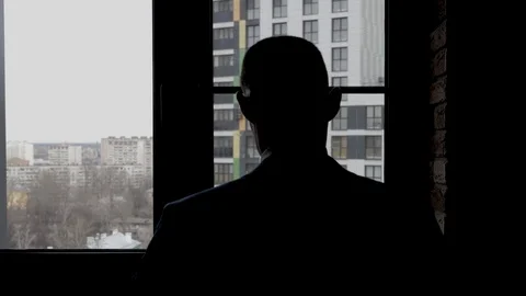 The silhouette of the guy in front of the window. Stylish frames Stock Footage 125950994