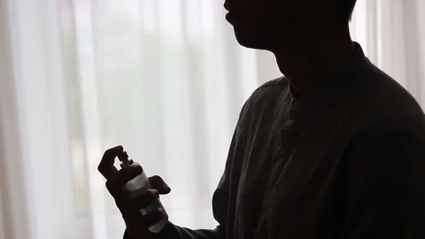Silhouette of a guy putting on a perfume Stock Footage 96986635