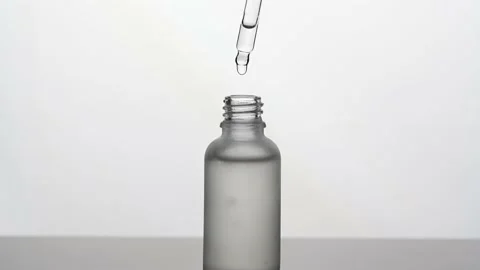 Silhouette of hand dripping serum drops into glass bottle 動画素材 170814681