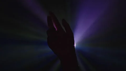 Silhouette of Hand Opening Up with Colourful Lights Stock Footage 156591904