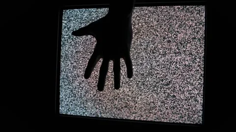 Silhouette Hand Reaching Out From Static Television Screen Stock Footage 307941660