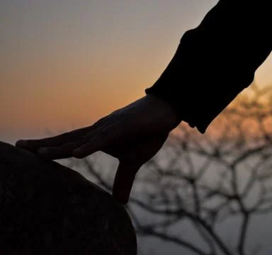 Silhouette hand on a rock Stock Photos