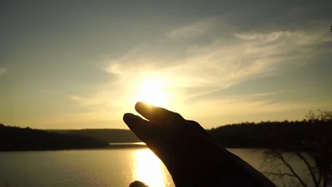 Silhouette hand touching the sun during the sky sunset. Видео 115758144