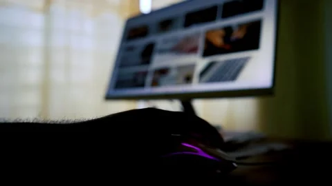 Silhouette of a hand using a computer mouse with a blurred monitor in the b.. Stock Footage 315981080